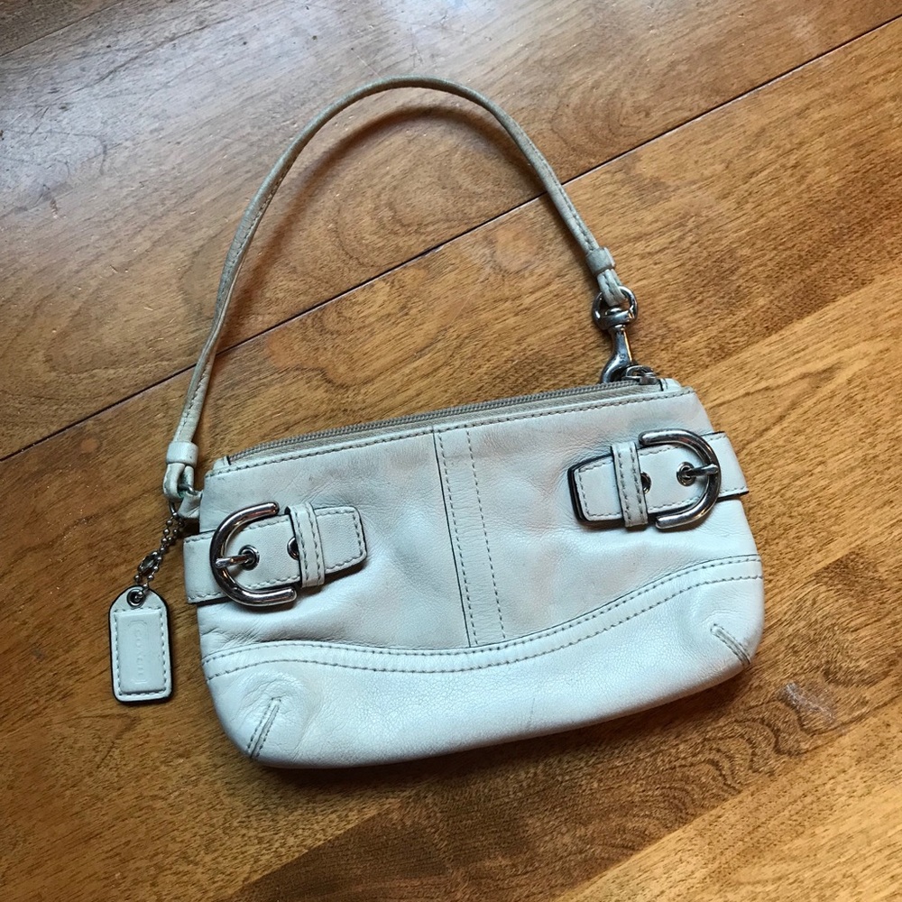 Off-white COACH brand leather wristlet.